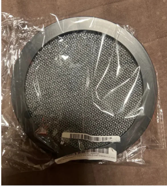 Round metallic filter with a clear plastic wrap on a brown surface